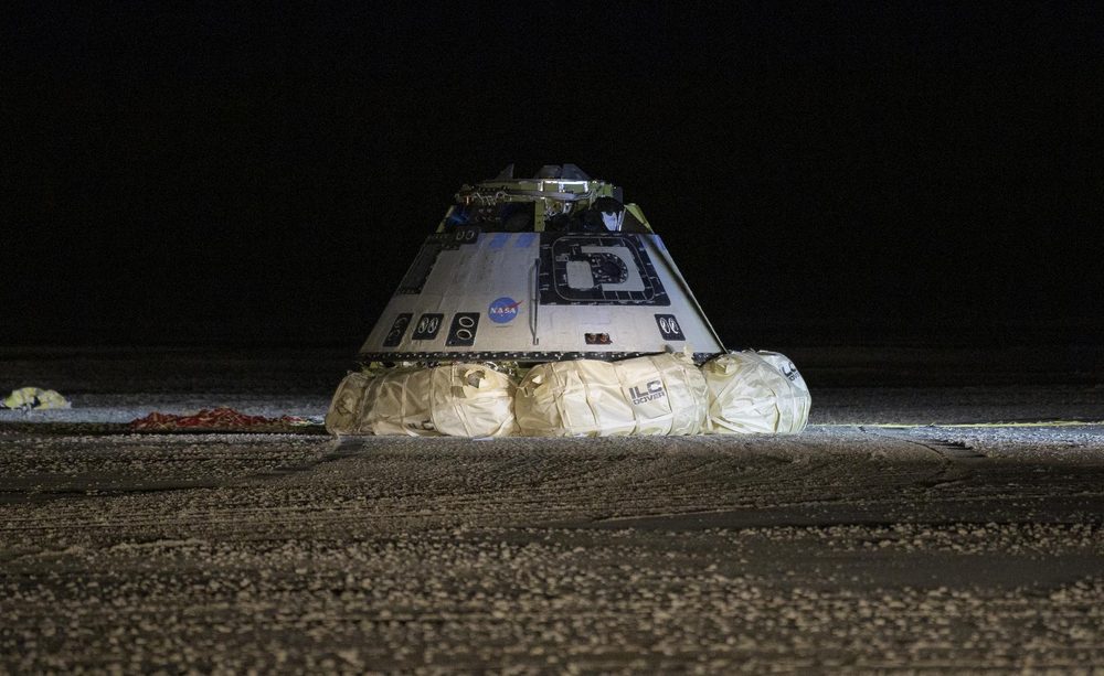 A blunt cone lit against the dark, resting on inflated bags on bare ground